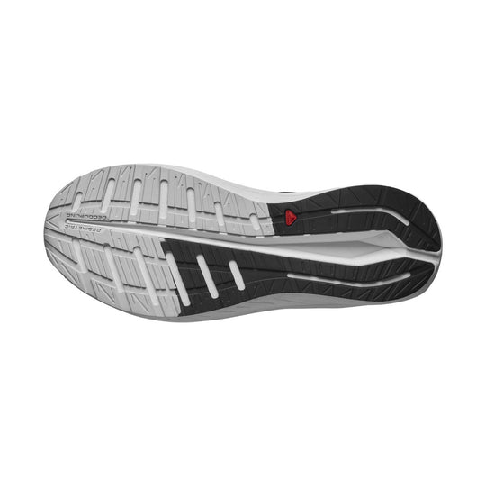 Running shoe outsole in gray and black with tread grooves and a small red Salomon logo