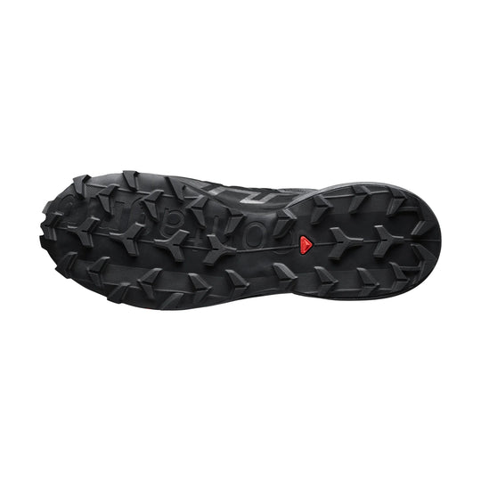 Black trail shoe outsole with aggressive lugs and a small red Salomon mark