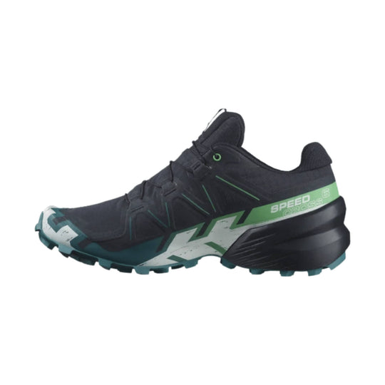 Black trail running shoe with green accents and rugged lugged sole, side view