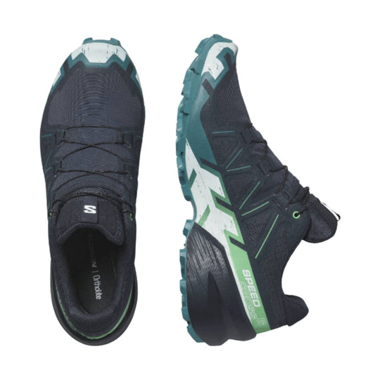 Dark trail running shoe with teal and white sole details, shown from top and side views