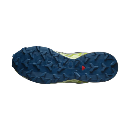 Blue trail running shoe outsole with deep aggressive lugs and a small red triangular accent