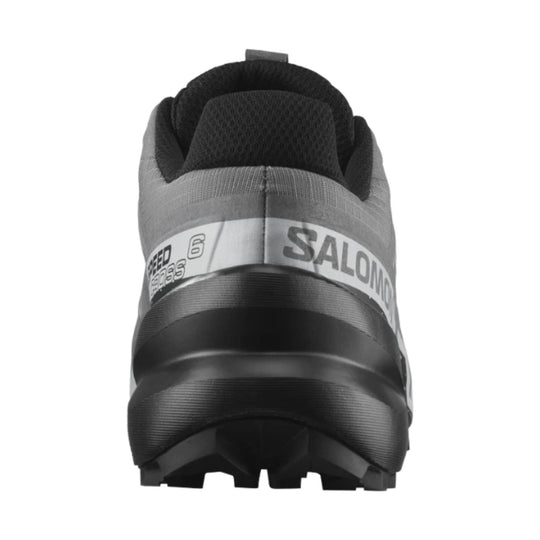 Rear view of a black and gray trail running shoe with chunky tread and visible Salomon branding