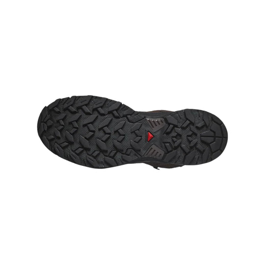 Black lugged boot sole with deep tread and a small red triangular accent