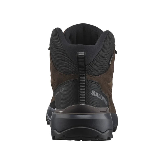 Rear view of a brown and black mid hiking boot with lugged sole and SALOMON branding