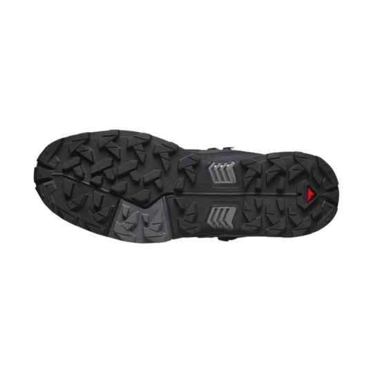 Black hiking boot outsole with deep lugged tread and a small red triangular logo