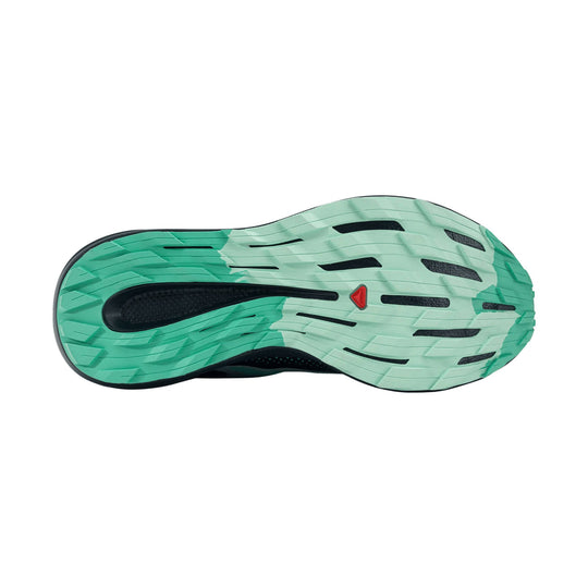 Mint green trail shoe outsole with black cutouts and a small red Salomon logo