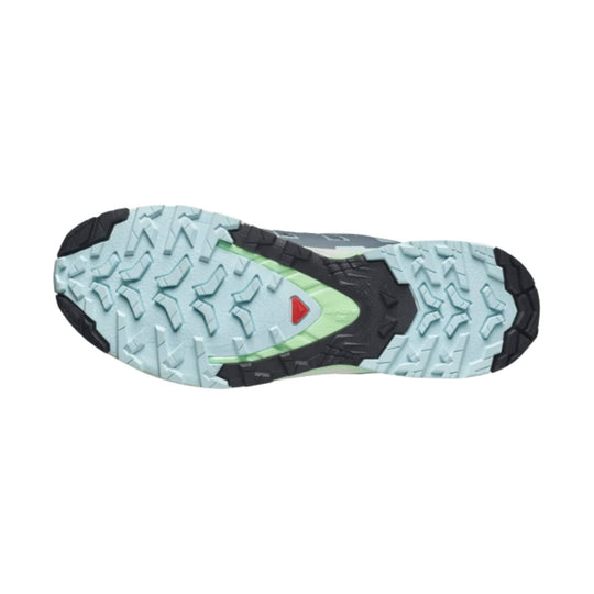 Trail running shoe outsole with light blue tread, black rubber sections, and a green midfoot accent
