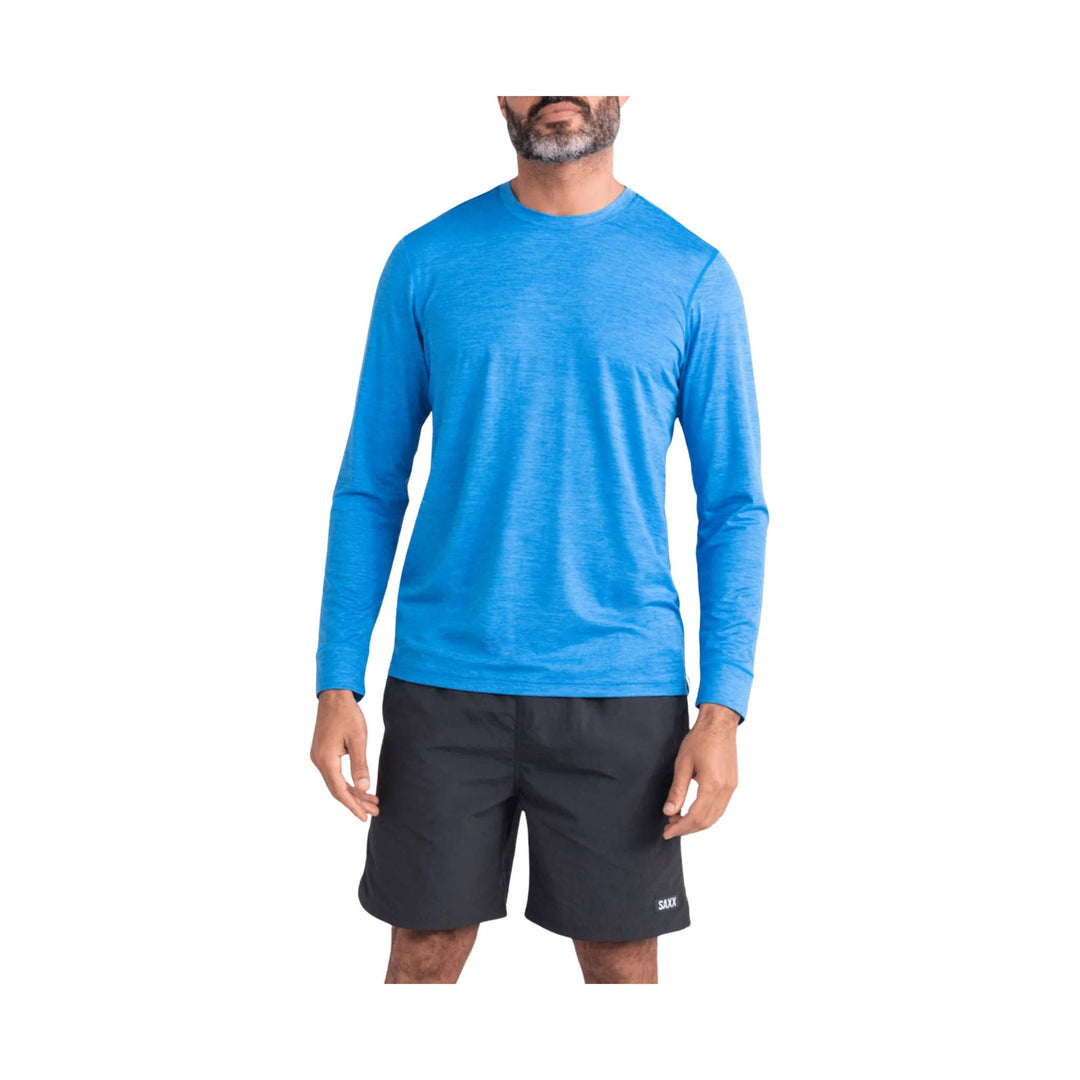 Man wearing a bright blue long-sleeve athletic shirt with black shorts.