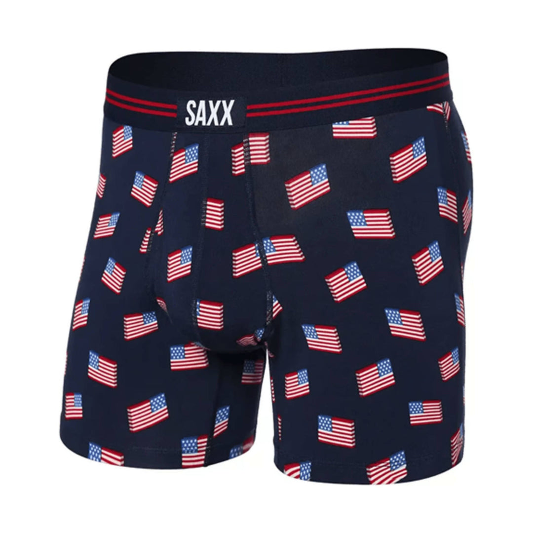 Navy boxer briefs with repeated American flag print and visible SAXX waistband logo