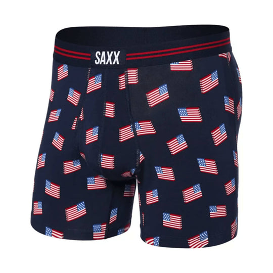 Navy boxer briefs with repeated American flag print and visible SAXX waistband logo