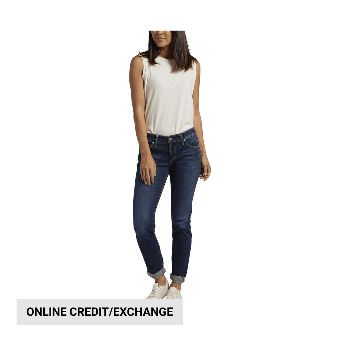 Slim dark wash jeans on a model with rolled cuffs