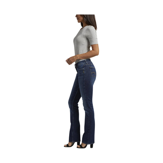 Woman wearing dark wash slim bootcut jeans with a gray T-shirt and black heels, side view