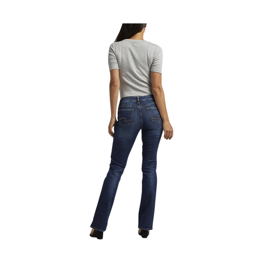 Back view of a woman wearing a light gray T-shirt and dark blue bootcut jeans