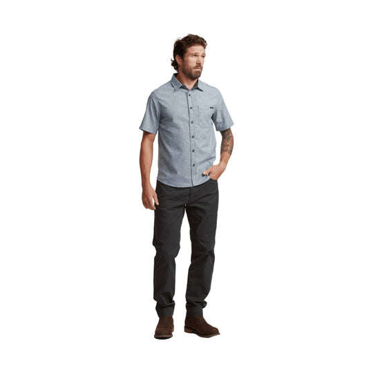 Light blue short-sleeve button-up shirt with chest pocket, shown with dark pants and brown boots on a male model