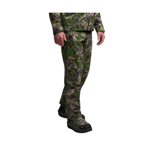 Green and gray camouflage hunting pants shown on a model, with black boots