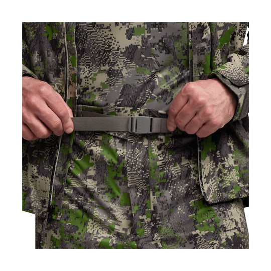 Camouflage zip-front pant with adjustable gray belt buckle, shown being fastened at the waist