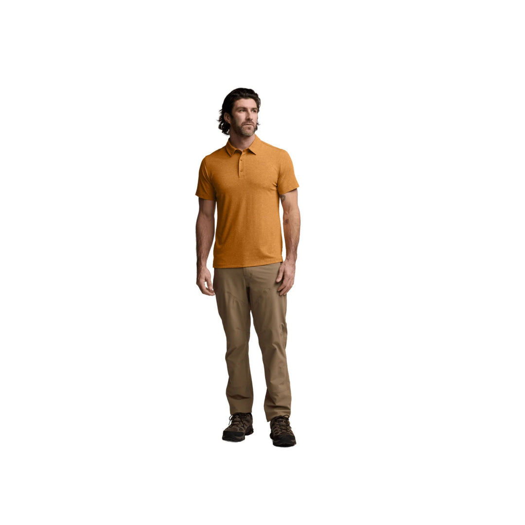 Men's short-sleeve button placket polo shirt in burnt orange, worn with tan pants and hiking shoes