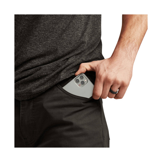 Man slipping a smartphone into the back pocket of black pants