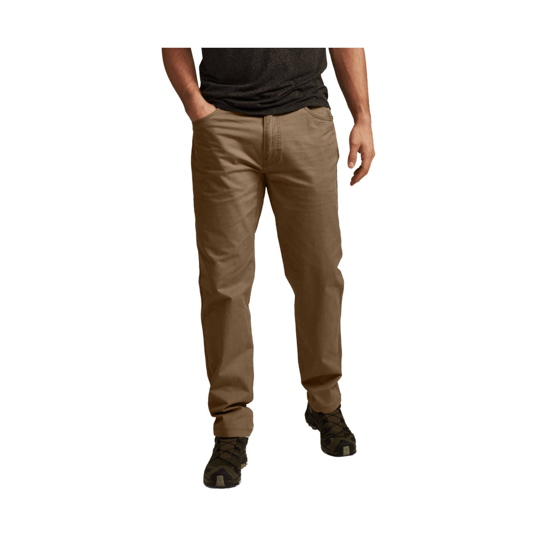 Brown straight-leg pants on a model with hands in pockets