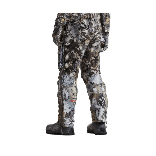 Camouflage insulated bib pants with side zippers and black boots, shown from the back
