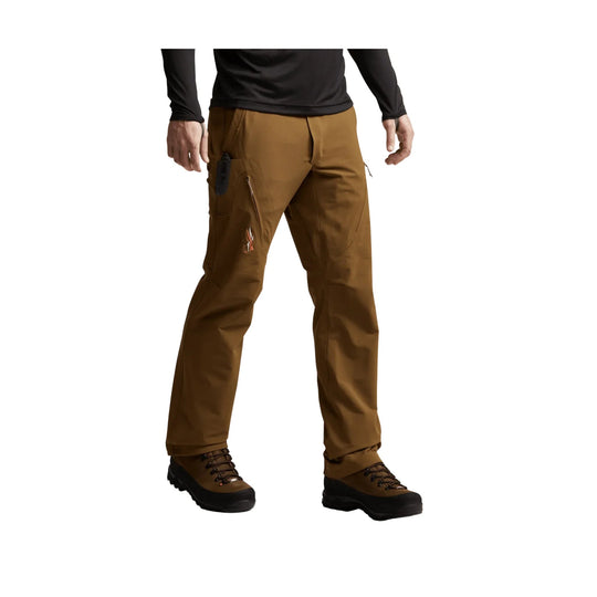 Brown cargo-style hiking pants with zippered thigh pockets and reinforced knees, shown with hiking boots