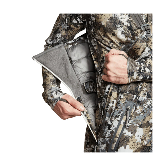 Camouflage insulated bib pants with a side zipper pocket and gray fleece-lined interior shown open