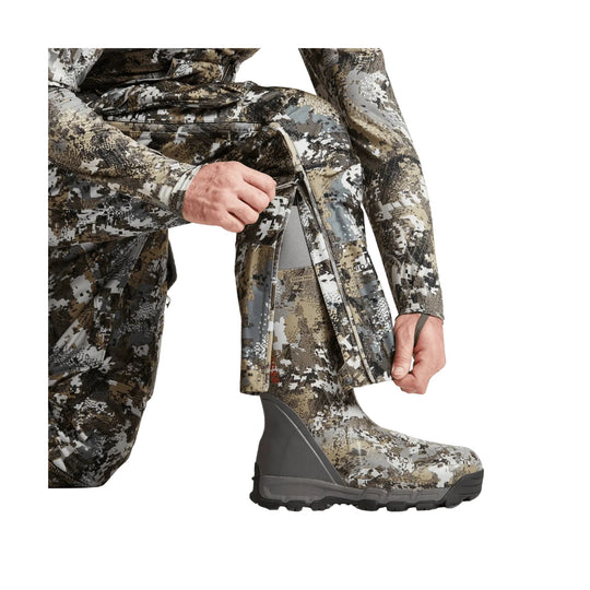 Camouflage insulated bib pants with side zipper and built-in boot gaiter, shown over a boot