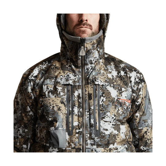 Camo hooded jacket with a front zipper, zip chest pockets, and orange logo on the chest