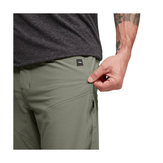 Olive green men’s pants with curved seam detailing and a zippered thigh pocket