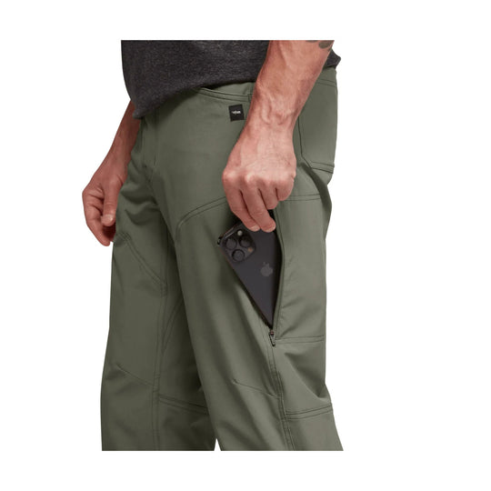 Olive green men’s pants with a zippered thigh pocket holding a black smartphone