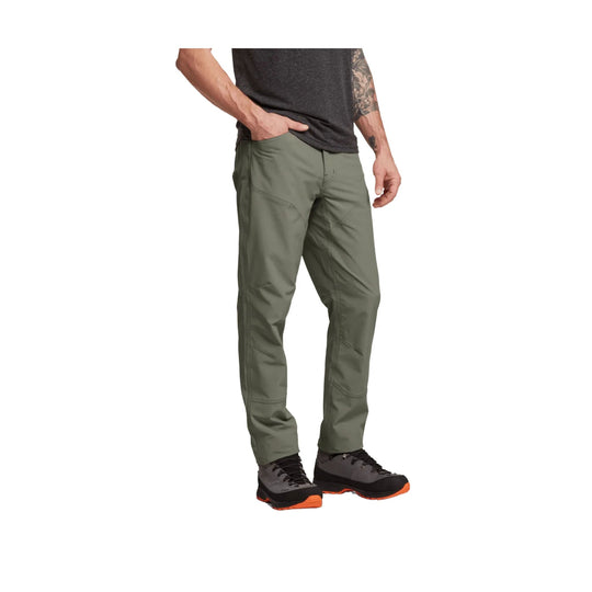 Olive green hiking pants with articulated seams, shown on a model wearing trail shoes