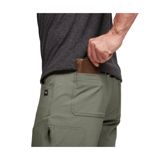 Olive green hiking pants with cargo pockets, shown from the back with a hand in the rear pocket