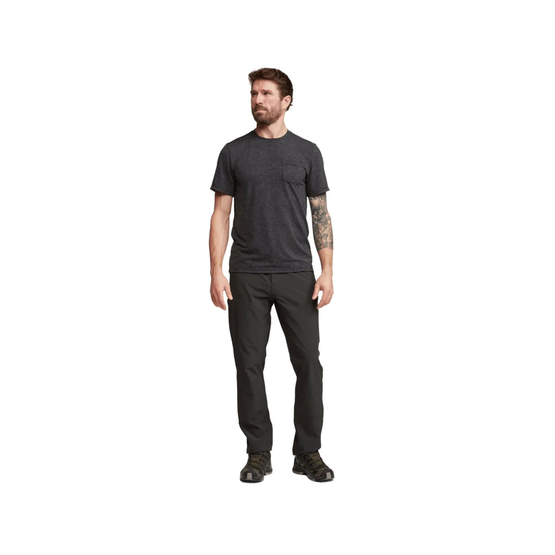 Man wearing black straight-leg hiking pants with a dark charcoal T-shirt and trail shoes