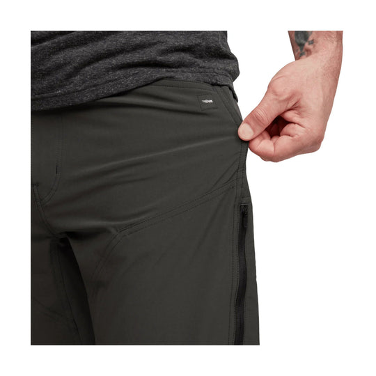 Black men’s pants with a stretch pull showing at the waist and a zippered thigh pocket