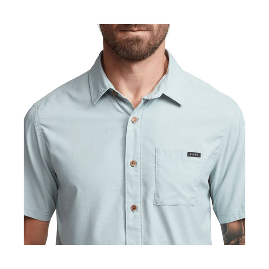 Light blue short-sleeve button-up shirt with chest pocket and small logo tag