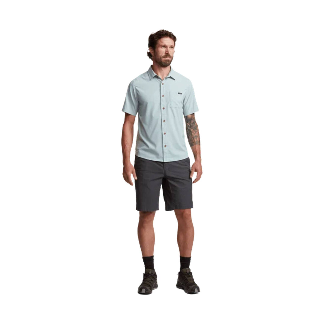 Light blue short-sleeve button-up shirt with chest pocket, worn with dark shorts
