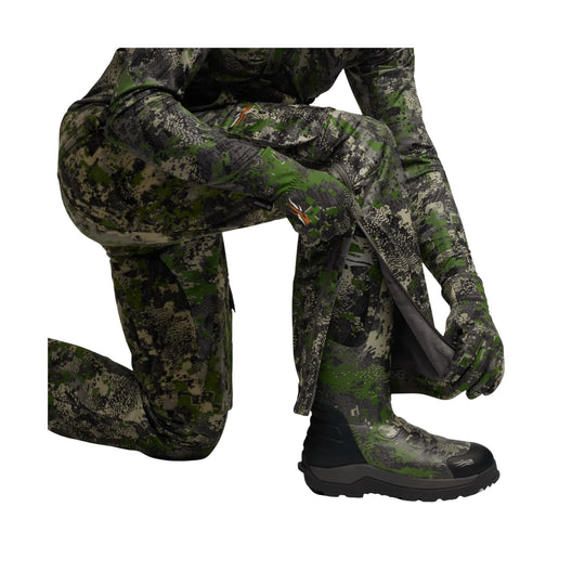 Camouflage hunting bib pants with attached boots, shown in a crouched pose