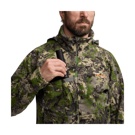 Camouflage zip-up jacket with a high collar, chest pocket, and orange chest logo