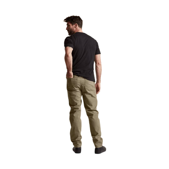 Man wearing black T-shirt and tan pants, shown from the back