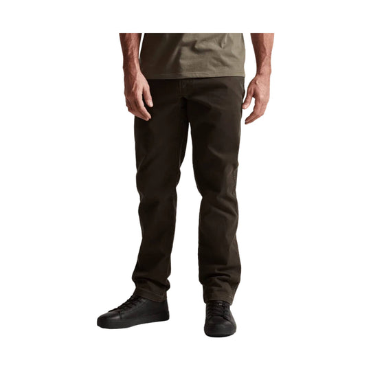 Dark brown straight-leg pants worn with black sneakers, shown from waist to shoes