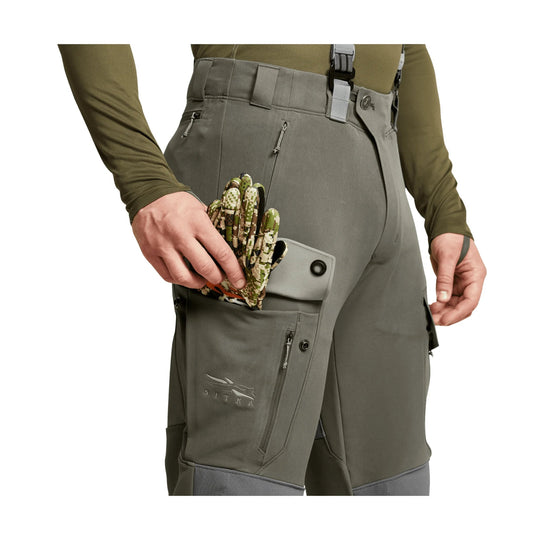 Gray technical cargo pants with side pockets, zipper thigh pocket, and visible SITKA logo