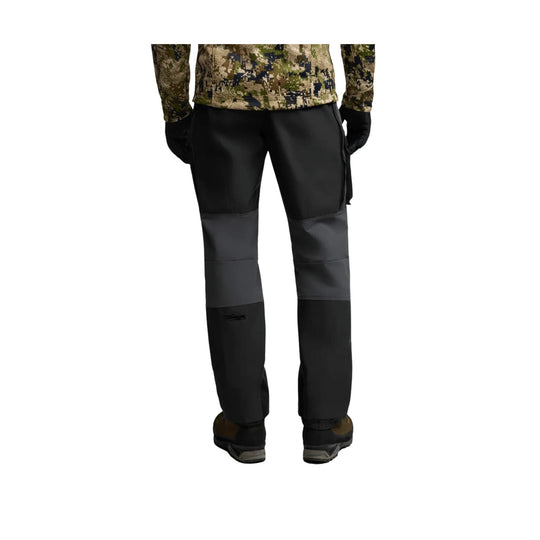 Black and gray men’s outdoor pants with reinforced lower legs, shown from the back