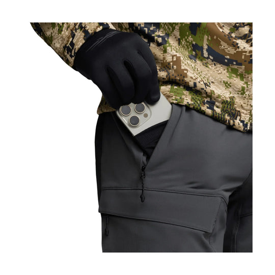 Black insulated cargo pants with a zippered thigh pocket, shown with a hand holding a smartphone.