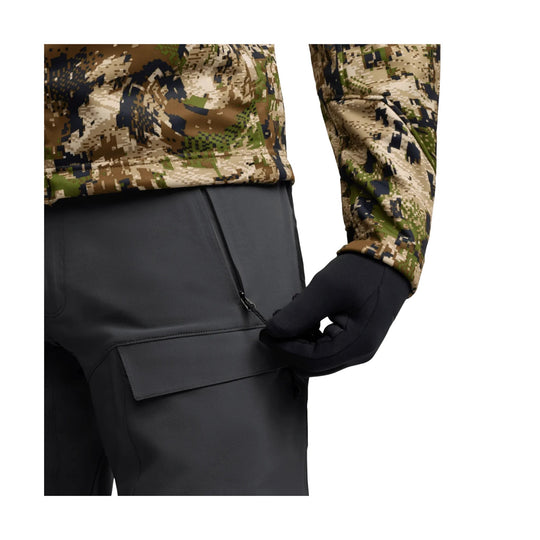 Camouflage long-sleeve top with black gloves and black cargo pants showing a zippered thigh pocket