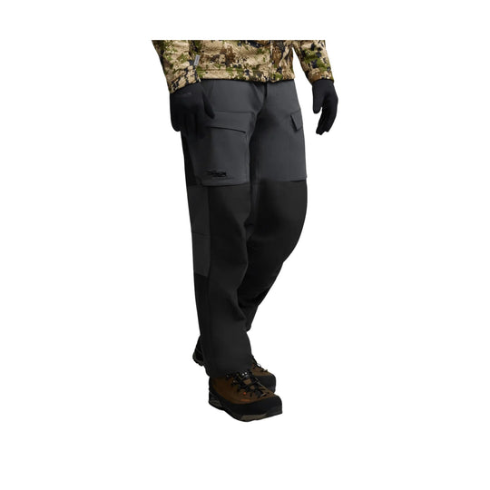 Dark gray and black cargo hiking pants with reinforced knees, worn with brown-and-black hiking boots