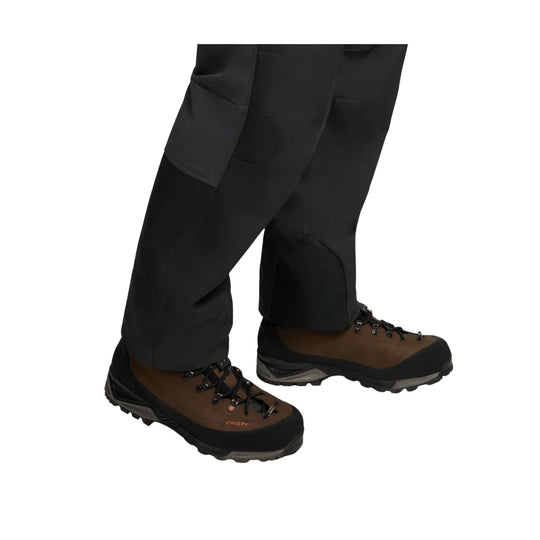 Black and brown mountaineering boots with laces and rugged soles