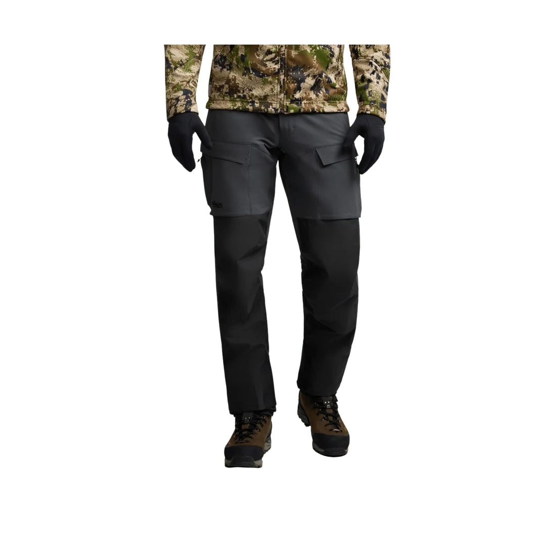 Black hiking pants with cargo pockets and articulated knees, shown with brown-and-black boots