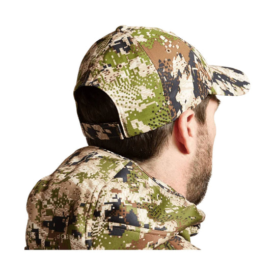 Camouflage baseball cap worn backward with matching camo outerwear, shown from the back and side