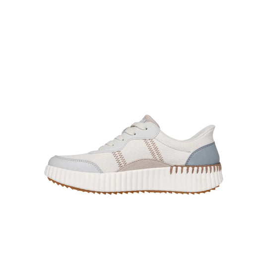 White slip-on sneaker with light gray panels, zigzag stitching, and a thick ridged platform sole