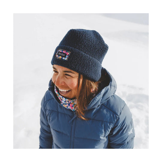 Floral fleece neckwarmer worn under a navy beanie and blue puffer jacket